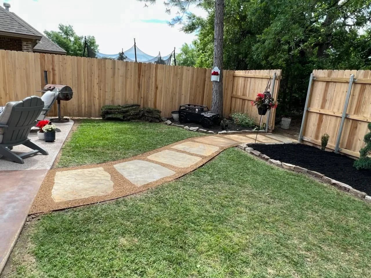 Flagstone walkway set in gravel along a cedar fence in Bryan, Texas