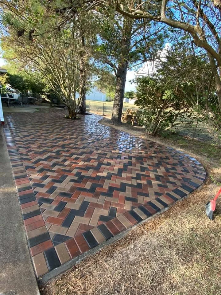 Herringbone paver patio in red and charcoal beside a lawn