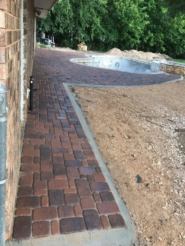 Paver walkway laid alongside a home during construction
